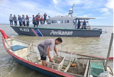 Mohd Zolkafly (dua dari kiri) meninjau pelepasan benih kerang ketika meninjau 24 lot kebun kerang di Bagan Datuk pada Jumaat.