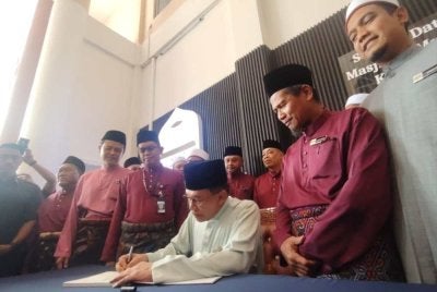 Anwar menandatangani buku pelawat pada Program Solat Jumaat Bersama Perdana Menteri di Masjid Muqarabin, Bandar Tasik Selatan di Kuala Lumpur pada Jumaat.