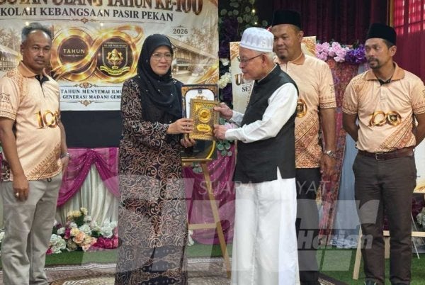 Siti Norina (dua dari kiri) menyampaikan anugerah kepada Nik Abdul Kadir (tiga dari kanan) pada majlis Sambutan 100 tahun Sekolah Kebangsaan Pasir Pekan di Dewan Nahkoda Haji Wan Ali, Tumpat pada Jumaat.