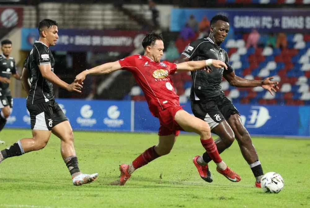 Pemain Sabah FC, Darren Lok (dua, kanan) dikawal ketat oleh dua pemain pertahanan Terengganu FC pada aksi Liga Super di Stadium Likas malam Sabtu. Foto Bernama