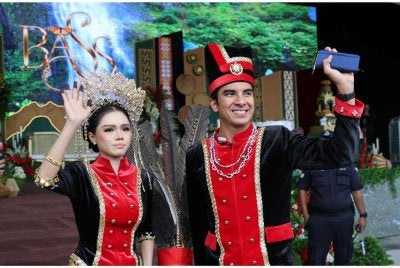 Ahli Parlimen Muar, Syed Saddiq Syed Abdul Rahman bersama isterinya, Bella Astillah, tampil anggun mengenakan busana tradisional suku kaum Kedayan Sabah sambil melambaikan tangan kepada orang ramai pada majlis Kenduri Rakyat sempena perkahwinan mereka di Padang Bandaraya Kota Kinabalu hari ini. Foto Bernama 