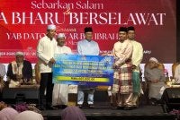 Simbolik penyerahan peruntukan projek penyelenggaran institusi agama disaksikan Anwar (tengah). 