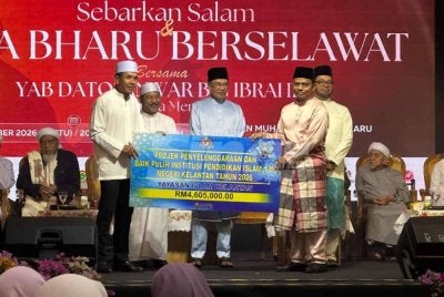 Simbolik penyerahan peruntukan projek penyelenggaran institusi agama disaksikan Anwar (tengah). 